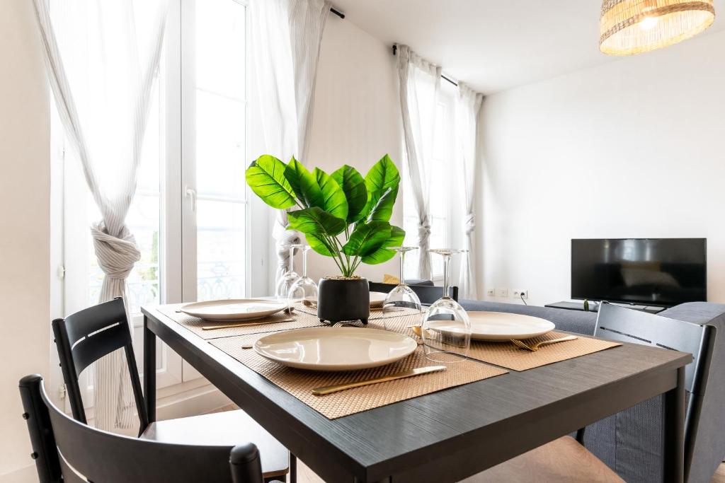 a dining room with a table with a plant on it at Appartement Terreau in Manosque