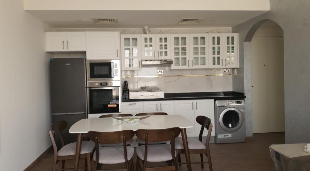 a kitchen with a table and chairs in it at Sharjah Rose Tower in Sharjah