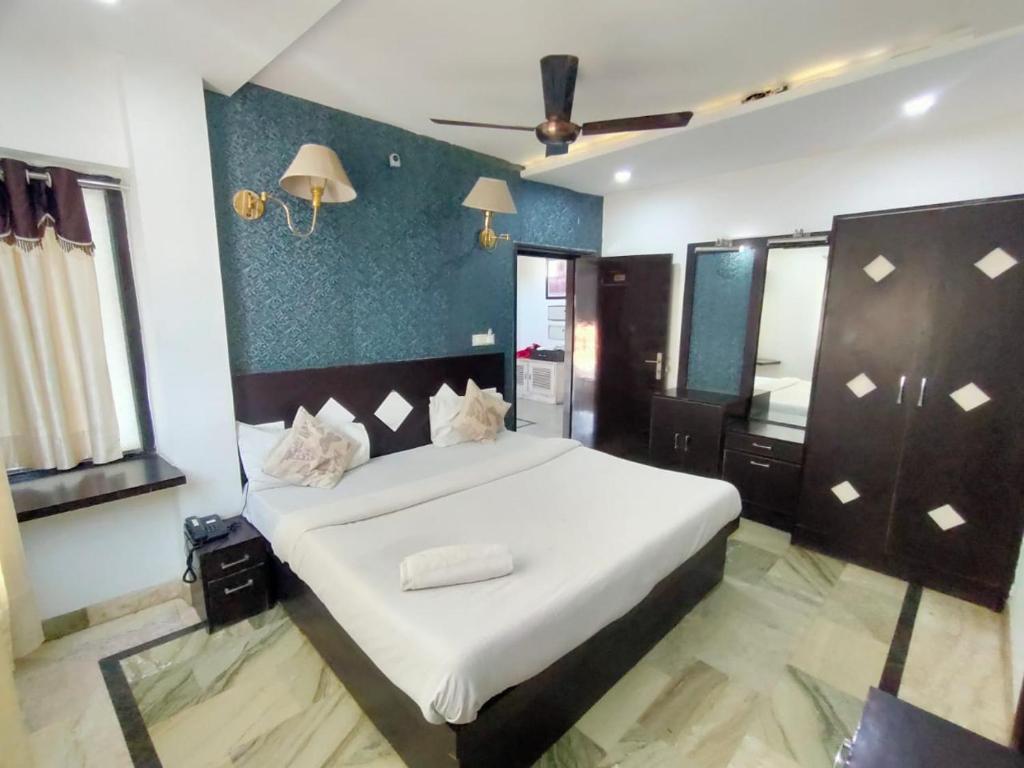 ein Schlafzimmer mit einem großen weißen Bett in einem Zimmer in der Unterkunft Hotel Laxman Resort by The Golden Taj Group &Hotels in Agra