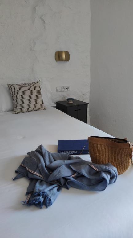 un libro y una cesta en una cama en Hostal Blavet, en Calaceite