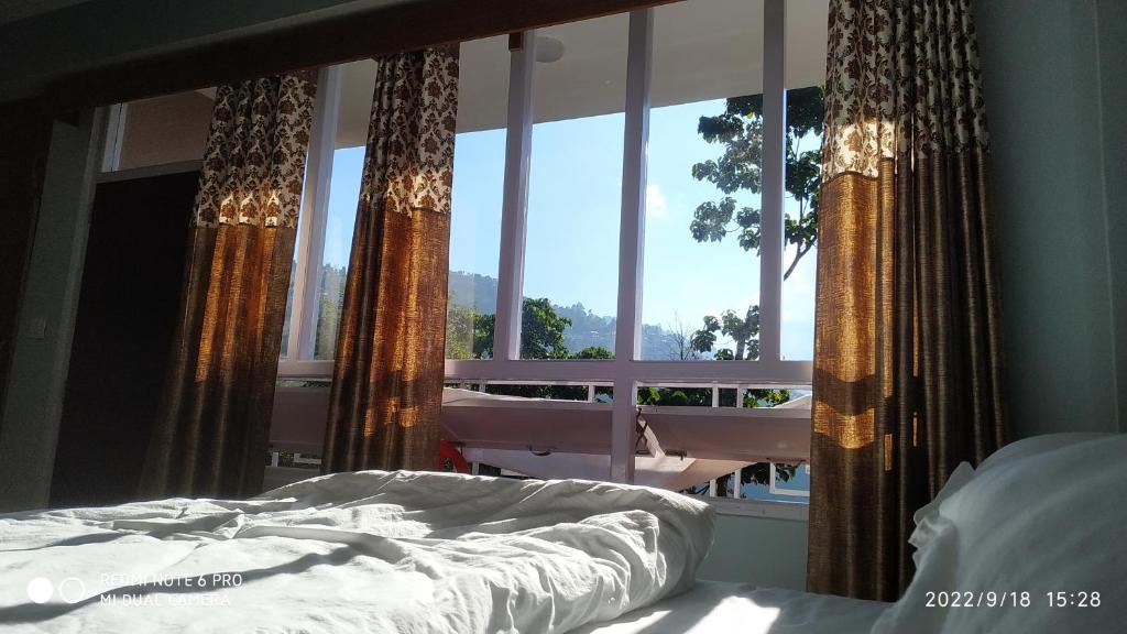 una camera da letto con un letto e una grande finestra di Mandavya homestay a Pelling