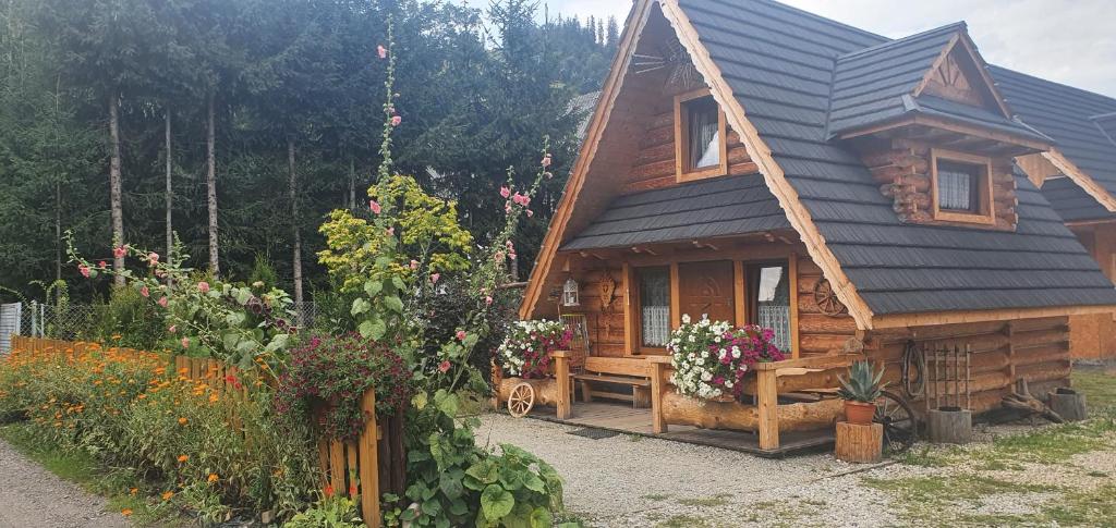 einem Blockhaus mit einer Bank davor in der Unterkunft Domki Harenda in Zakopane