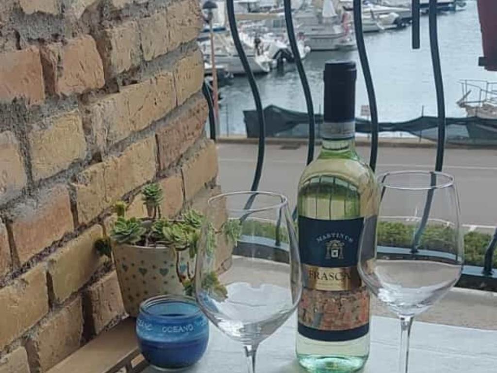een fles wijn en twee glazen op een tafel bij FRA EM DORIA in Nettuno