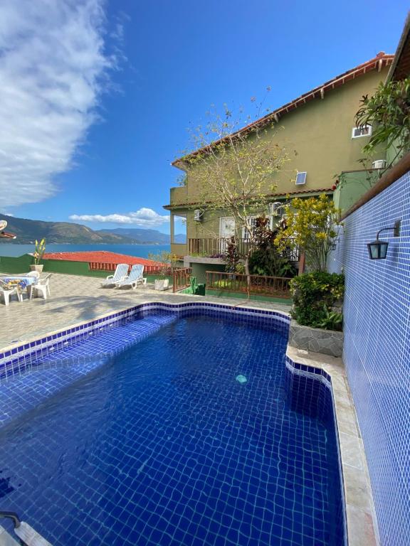 a swimming pool in front of a house at Pousada Platôdasilhas in Angra dos Reis