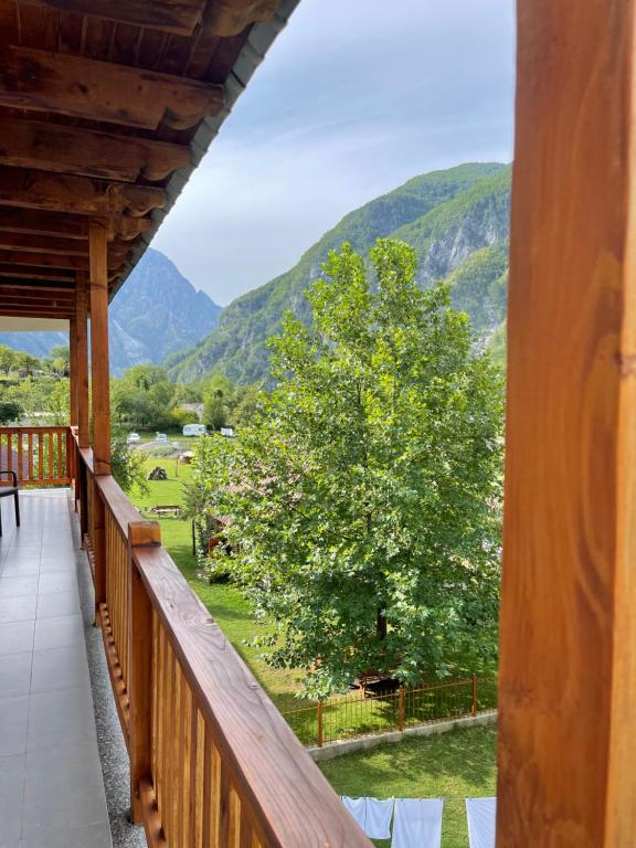 a balcony with a view of a tree and mountains at Thethi view in Gjelaj