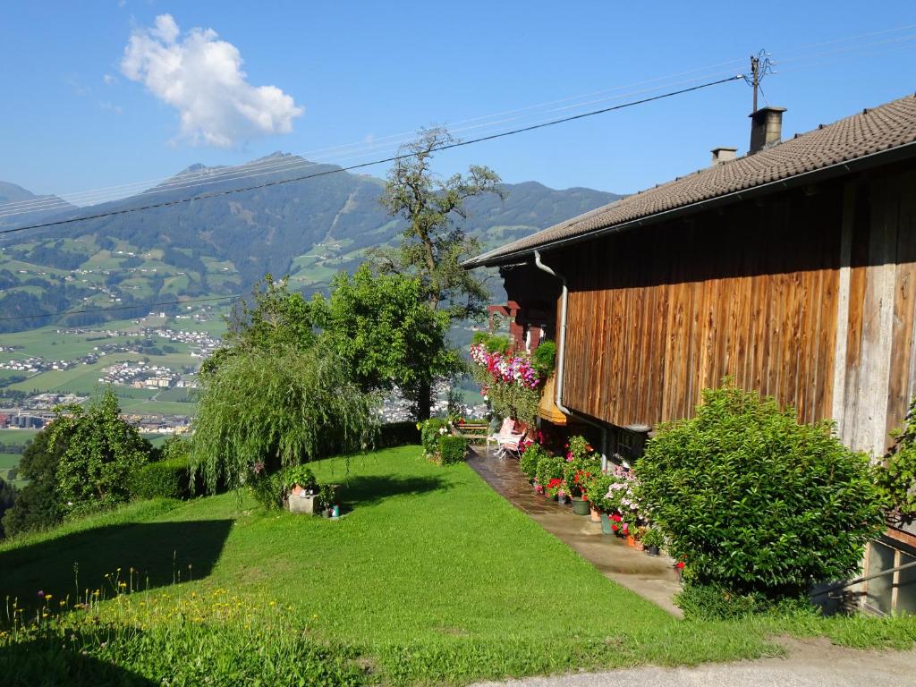 a garden next to a house with mountains in the background at Apart Ponholz in Hart im Zillertal
