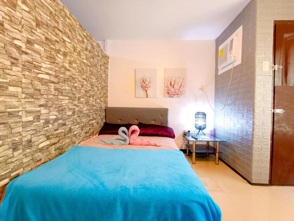 ein Schlafzimmer mit einem Bett mit zwei Handtüchern darauf in der Unterkunft UNO'S Place with Karaoke,Wifi,Netflix and Balcony in Anabu Primero