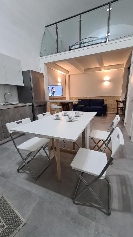 a white table and two chairs in a room at La Giara House in Corato