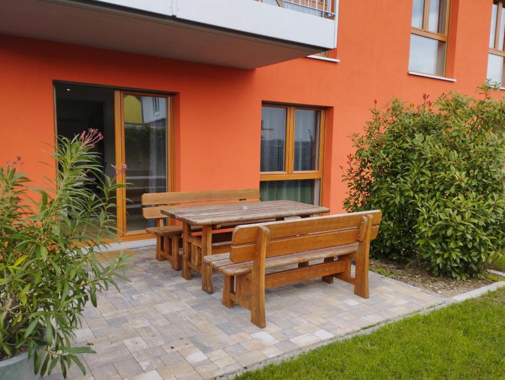 una mesa de madera y bancos frente a un edificio en RK Apartments Birnbaum en Gerhardshofen