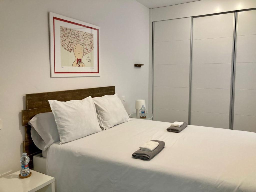 a bedroom with a large white bed with two towels on it at Apartamento centro con parking privado in Zaragoza