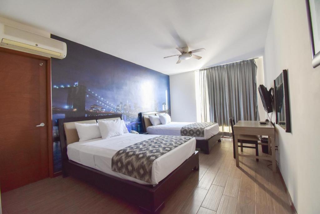 une chambre d'hôtel avec deux lits et un bureau ainsi qu'une chambre dans l'établissement Hotel TÖTEM Guadalajara, à Guadalajara