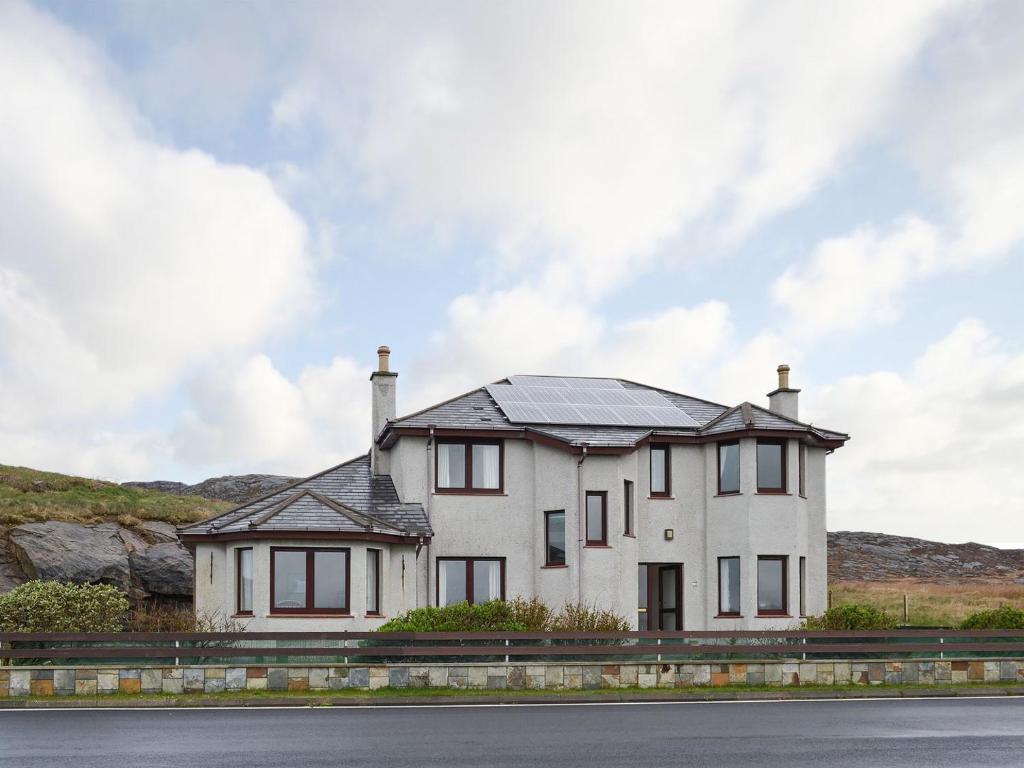 a house with a solar roof on the side of a road at Sealladh Lingeigh in Pollachar