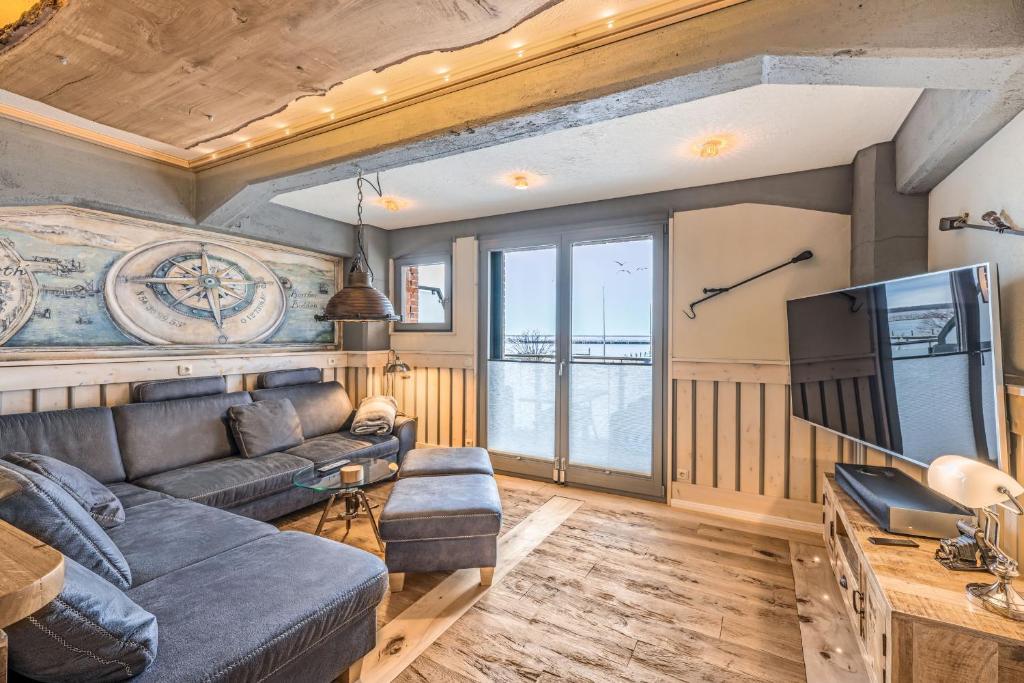 a living room with a couch and a tv at Lütt Haven in Barth