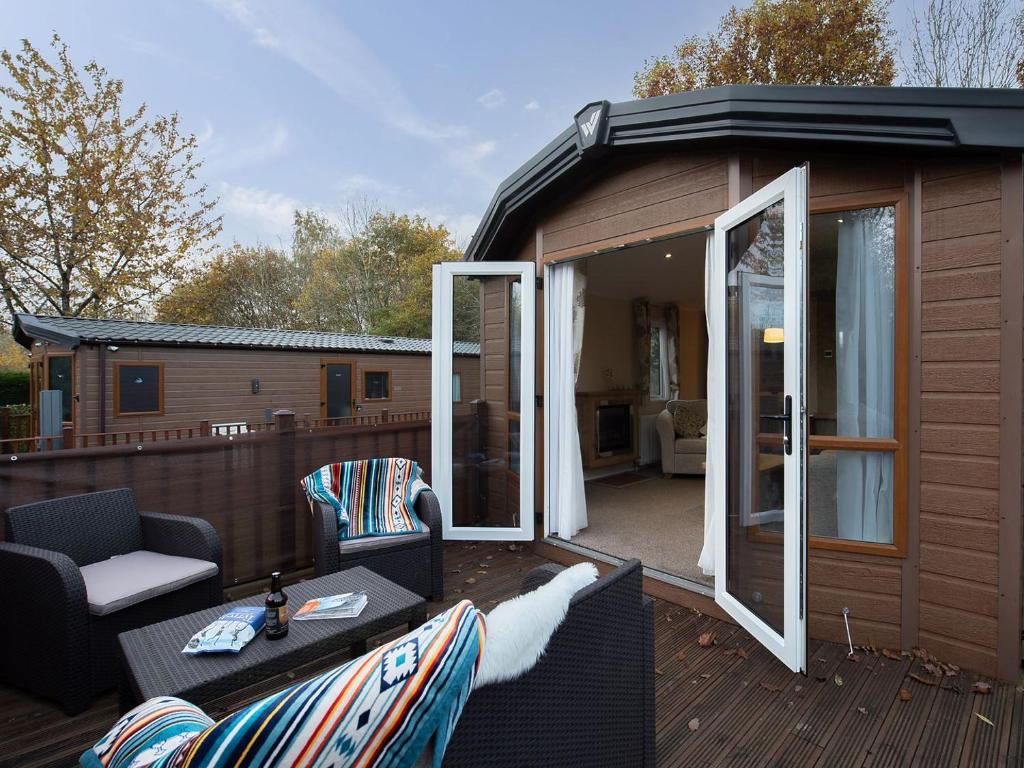 a large deck with a large sliding glass door at Winchester Lodge at Daisy Bank Caravan Park in Hyssington