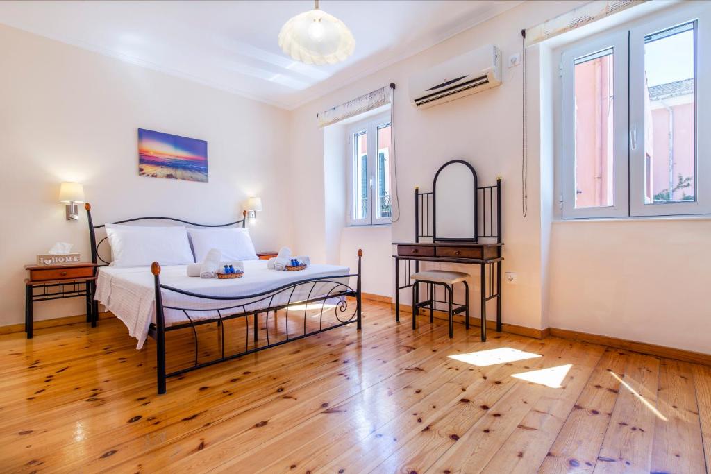 sypialnia z łóżkiem, stołem i oknami w obiekcie Rikki Apartment w Korfu
