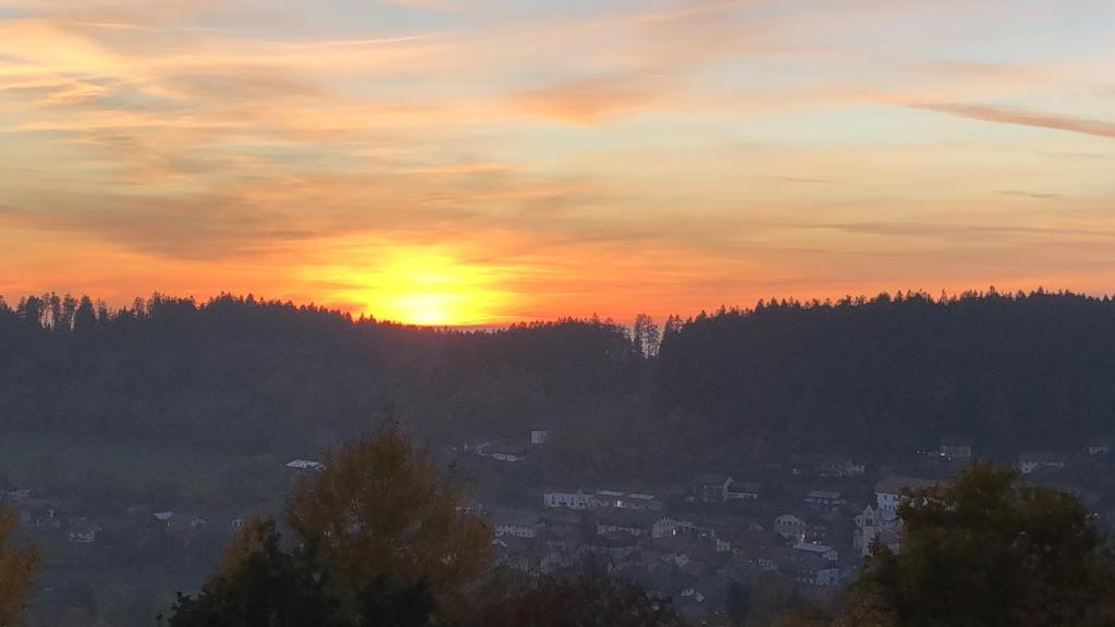 un tramonto con il sole che tramonta su una città di FERIENWOHNUNG FORSTPANORAMA a Sankt Englmar