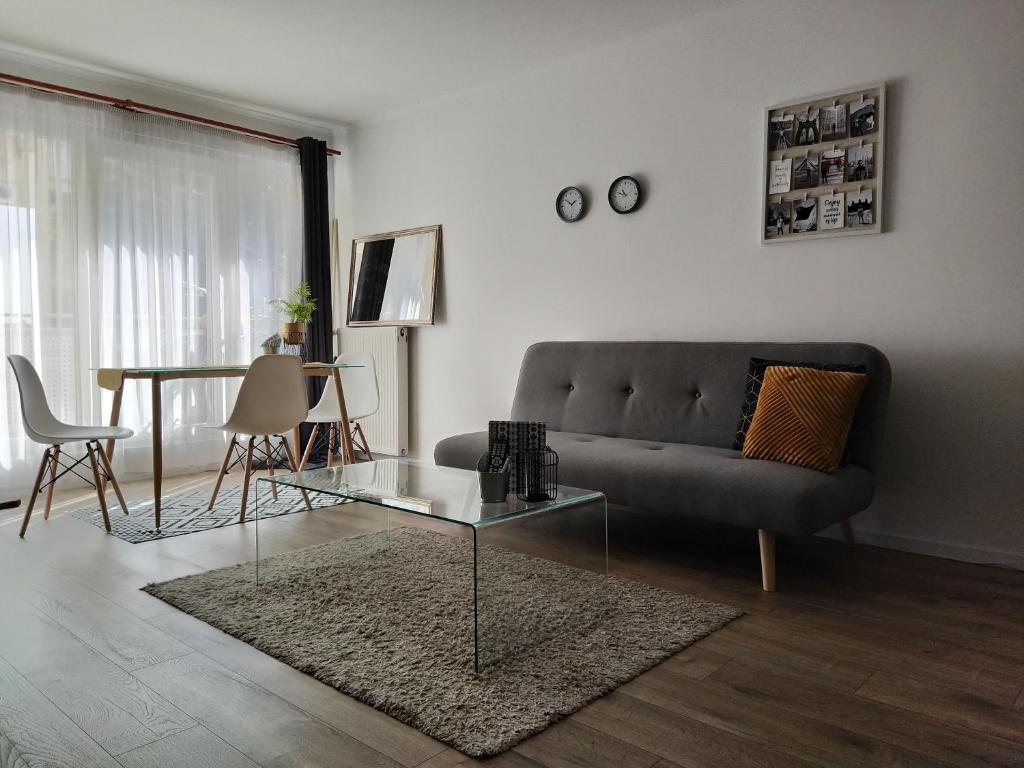 uma sala de estar com um sofá e uma mesa de vidro em Spacious apartment in hip neighborhood em Budapeste