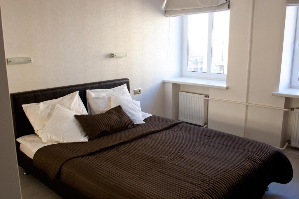 Un dormitorio con una cama grande con almohadas. en Nice & Cheap Apartment and FREE parking, en Riga