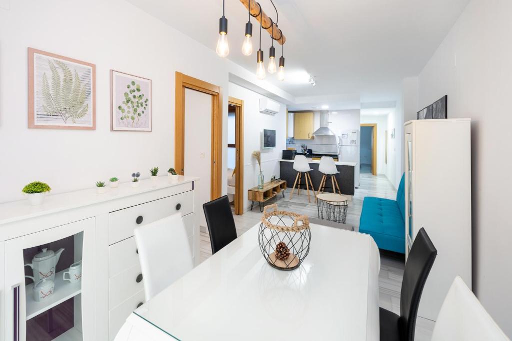 cocina y comedor con mesa blanca y sillas en Grace Apartments - 3 bedroom City Centre, en Granada
