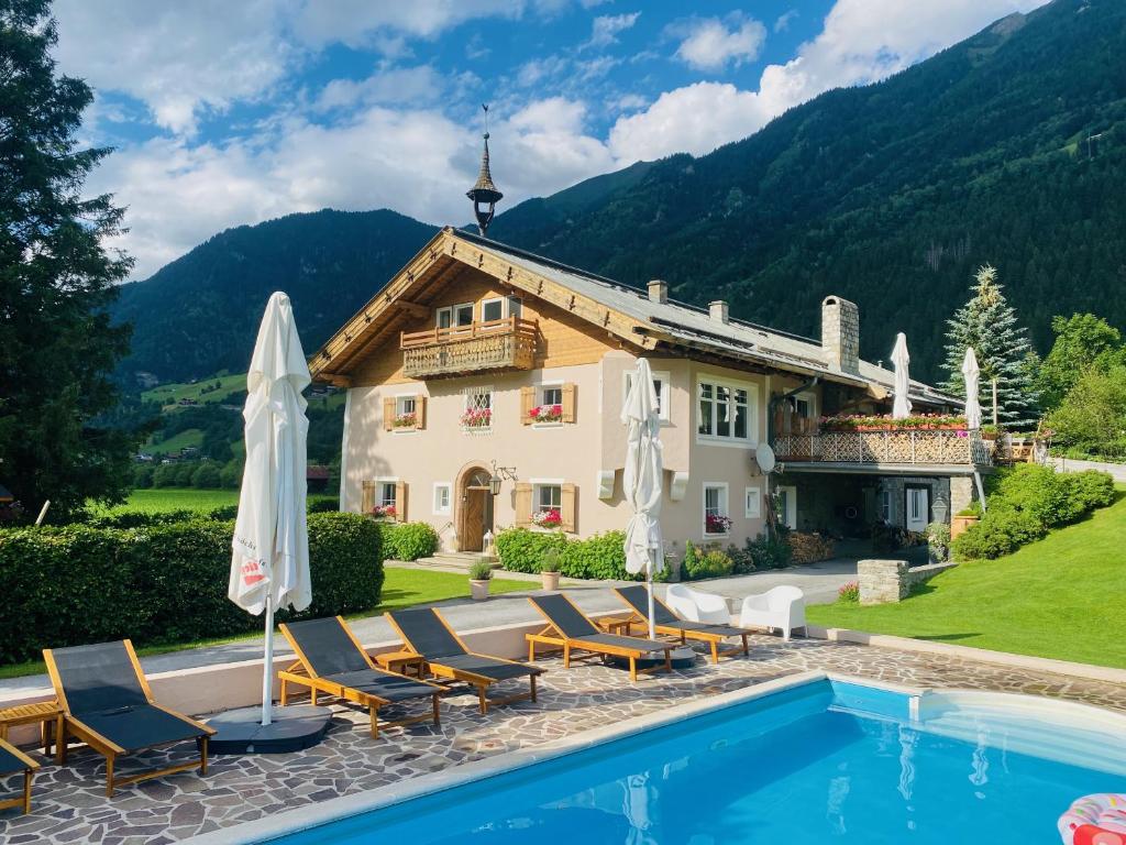 a villa with a swimming pool and a house at Landhaus Angerhof in Bad Hofgastein