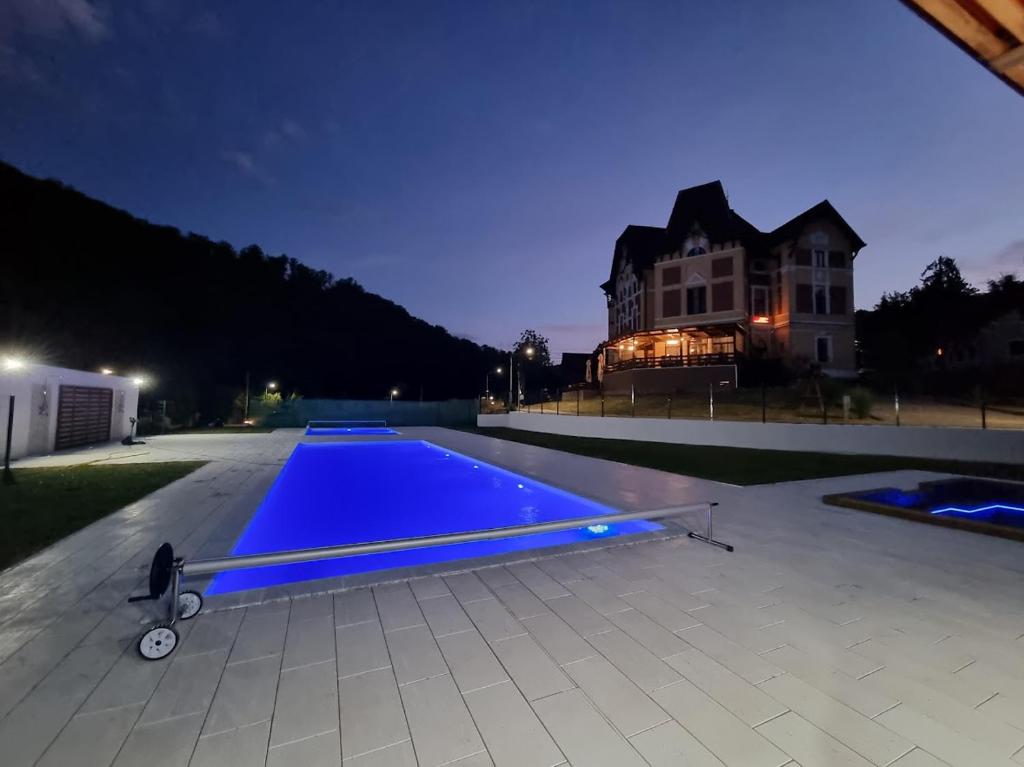 una piscina di fronte a una casa di notte di Pensiunea Mayumi Moneasa a Moneasa