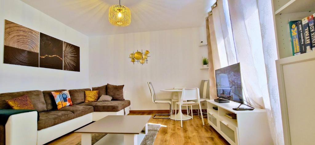 a living room with a couch and a table at Superbe appartement proche de toutes commodités. in Clermont-Ferrand