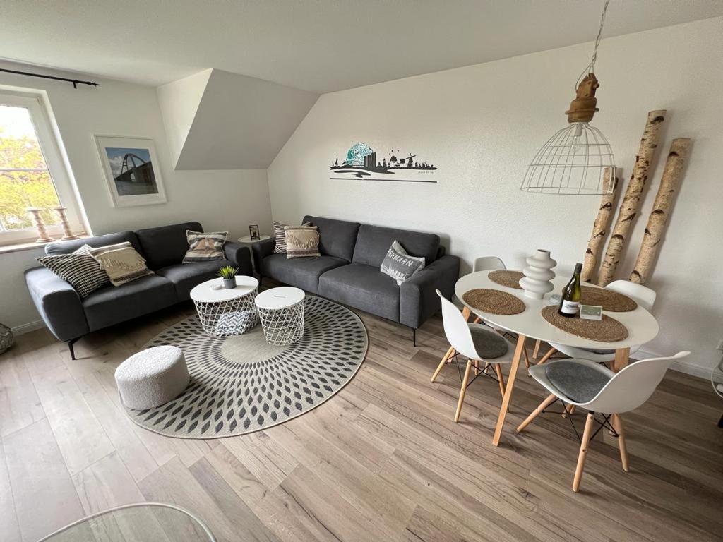 uma sala de estar com um sofá, uma mesa e cadeiras em Place to be Fehmarn em Fehmarn