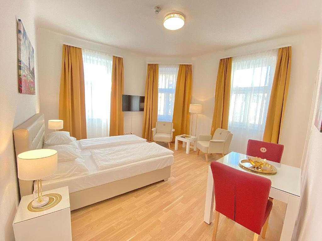 1 dormitorio con 1 cama, mesa y sillas en Steiner Residences Vienna Reumannplatz en Viena