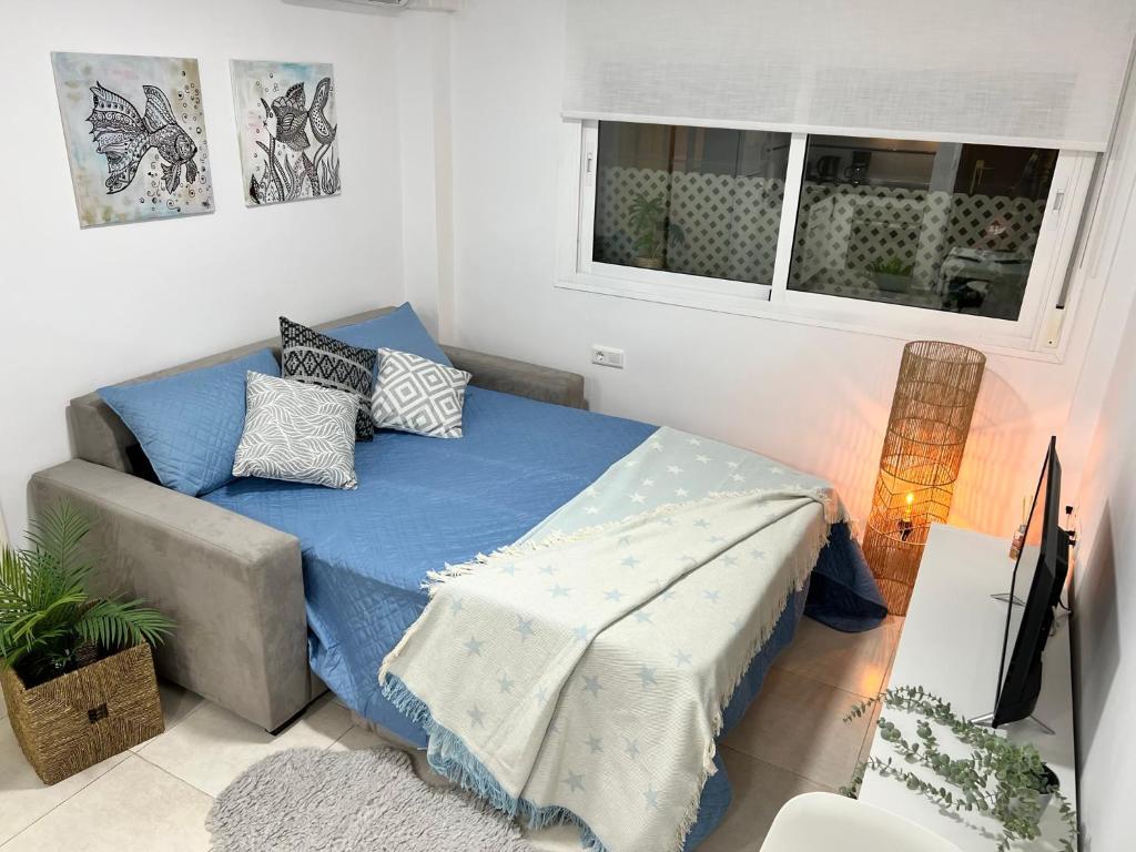 a bedroom with a bed and a couch and a window at Fuengirola Paseo Marítimo 27 in Fuengirola