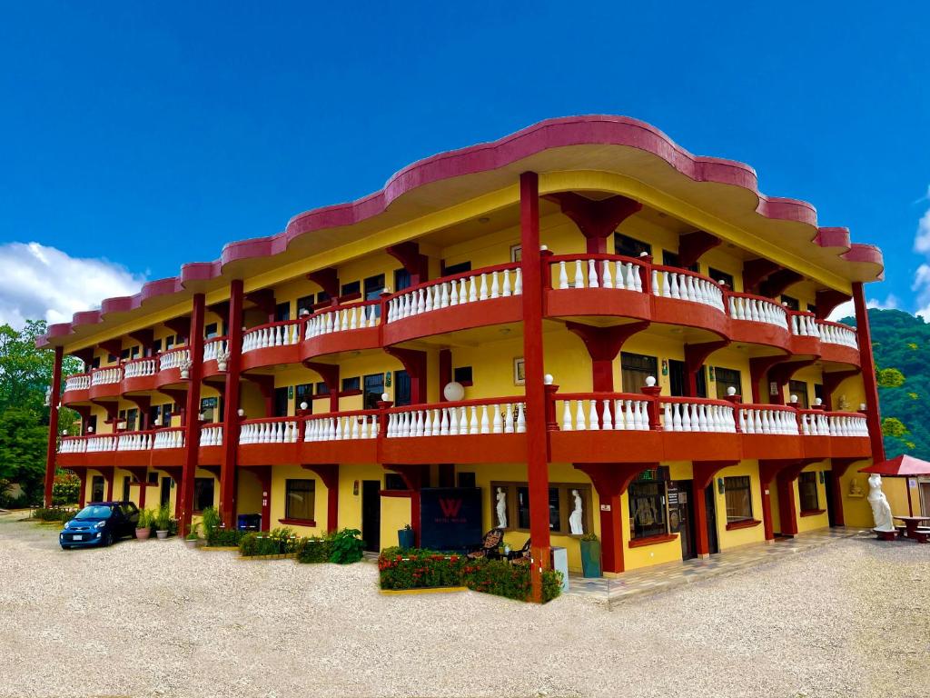 duży budynek z czerwonym i żółtym w obiekcie Hotel Wilson Ciudad Neily w mieście Neily