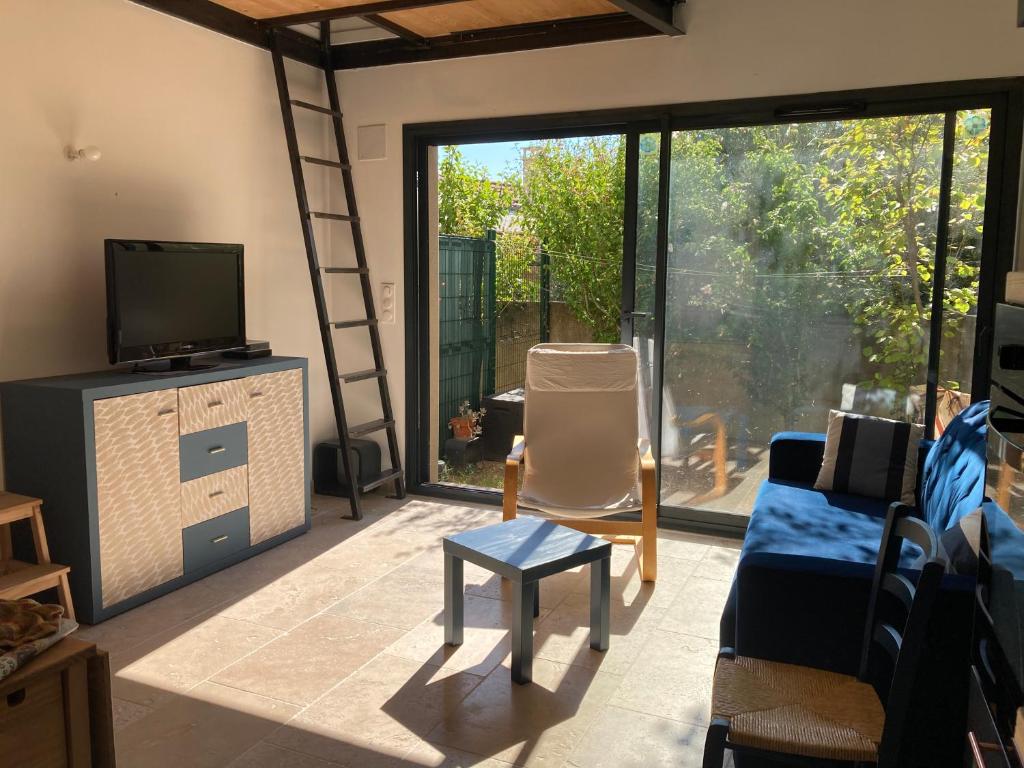 a living room with a large sliding glass door at Maisonnette avec jardinet et parking - Velleron in Velleron