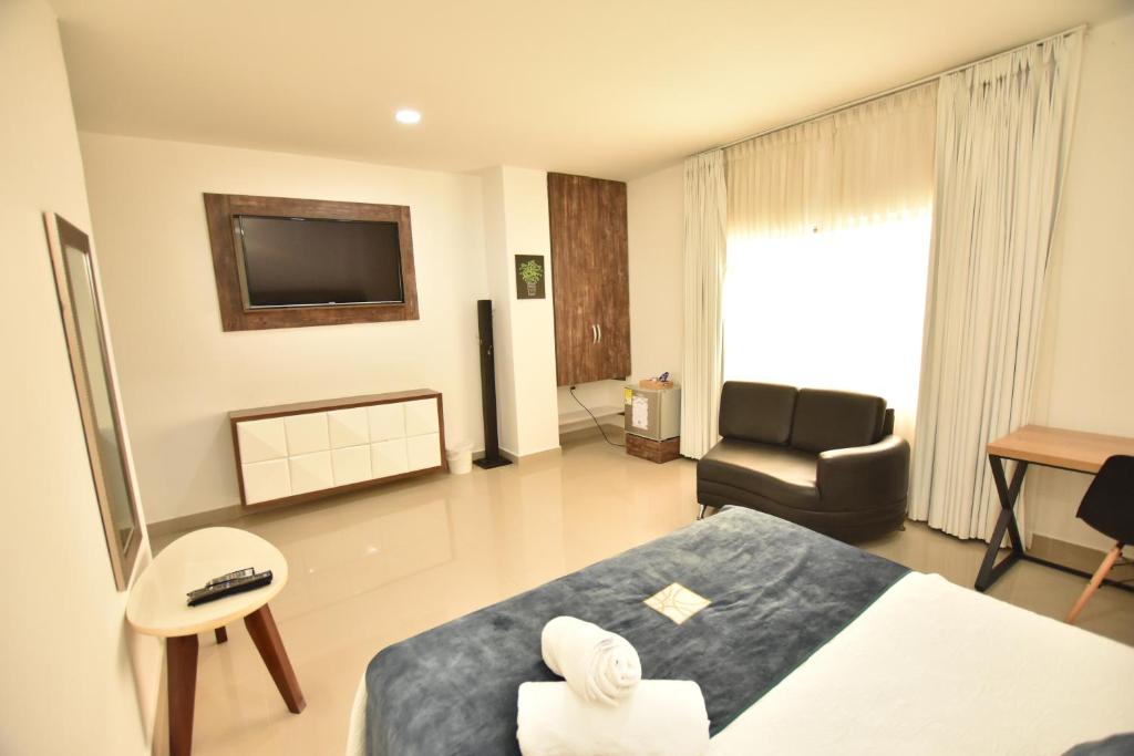 a hotel room with a bed and a chair at Hotel La Casa N. 3 in Montería