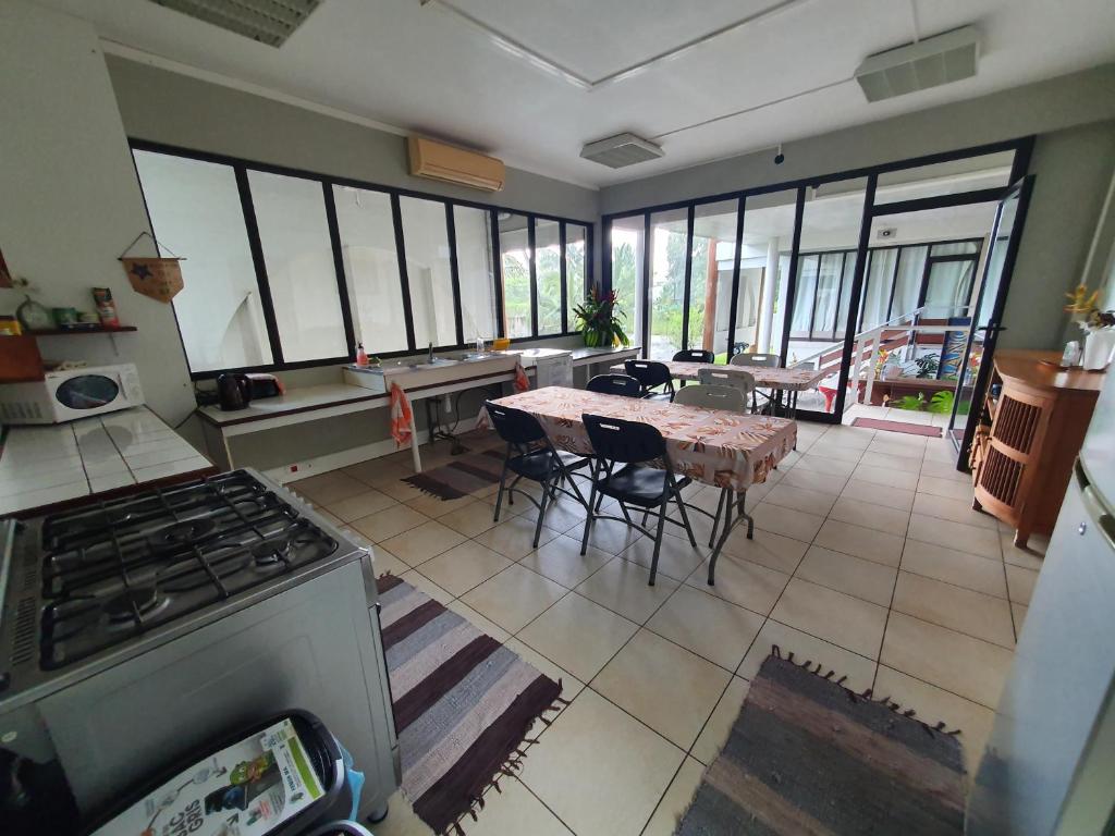 una cucina con piano cottura e tavolo con sedie di Residence Vainau Moorea a Haapiti