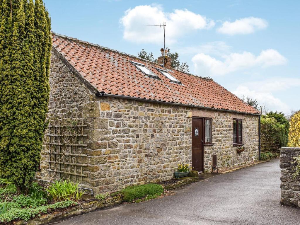 an old stone building with a red roof at Over Across-uk38277 in Cloughton