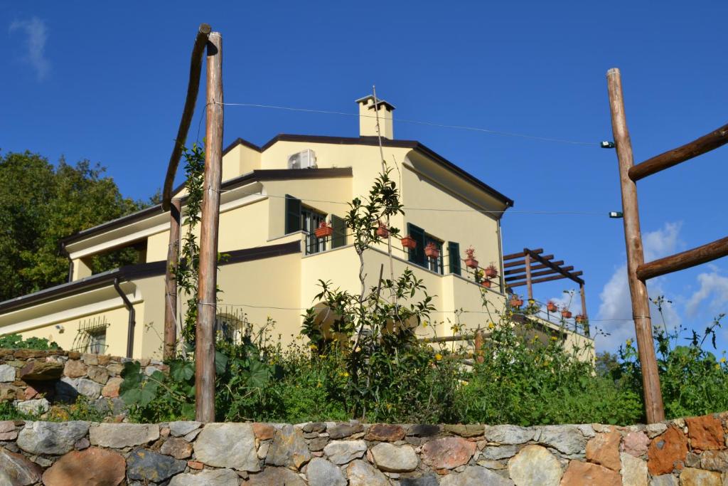 una casa en la parte superior de una pared de piedra en Joie de Vivre, en Calice Ligure
