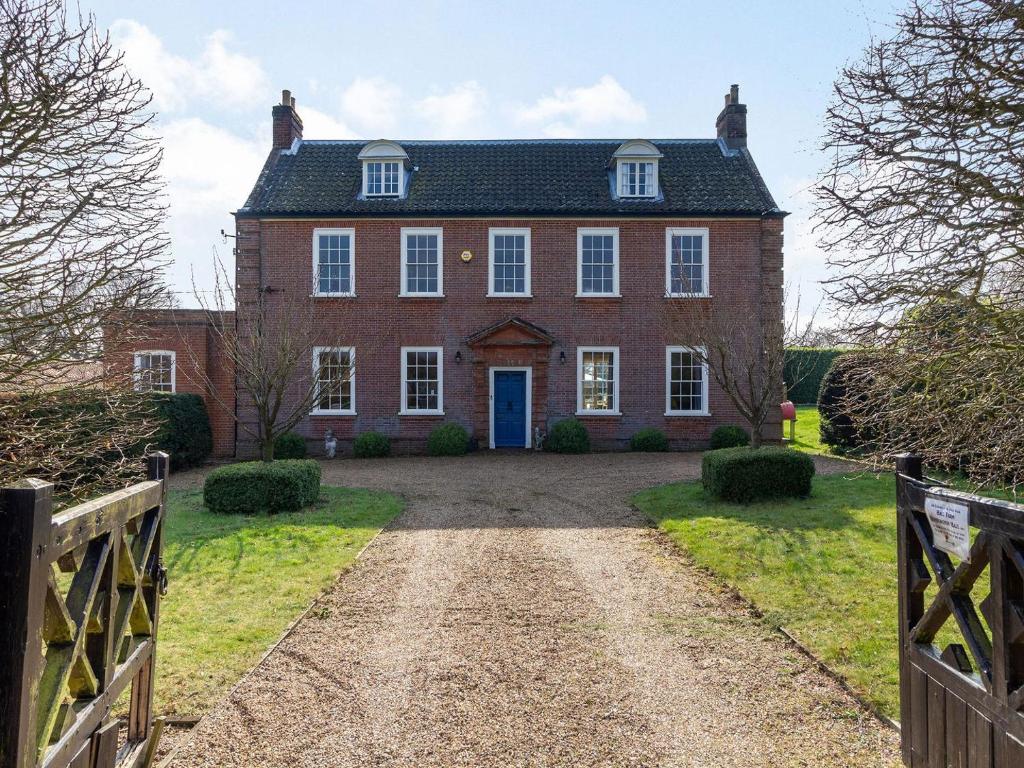 a large red brick house with a blue door at Hemblington Hall Arts And Leisure Ltd in South Walsham