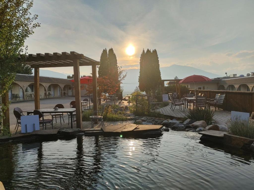 a pool with a table and chairs next to a lake at Magnuson Hotel Creston in Creston