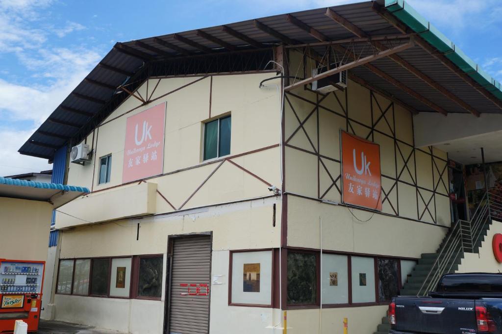 a building with two signs on the side of it at Unikarya Lodge in Kota Kinabalu