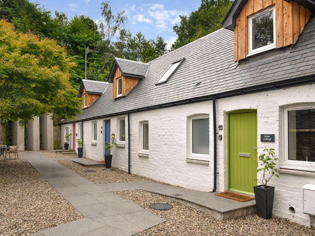 a row of houses with a green door at Hope Cottage - Uk40055 in Aberfeldy