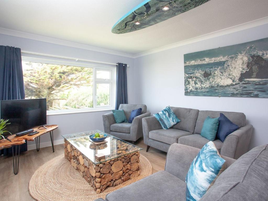 sala de estar con sofá y TV en Oceans, en Poundstock