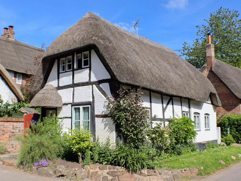 a thatched cottage with a thatched roof at Mortimer Cottage in Wootton Rivers