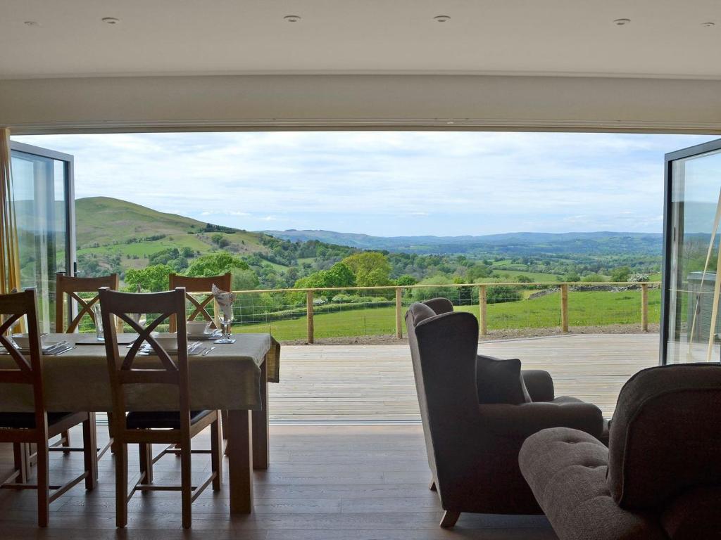 a dining room with a table and chairs and a view at Sweet Meadow Lodge in Llandrindod Wells