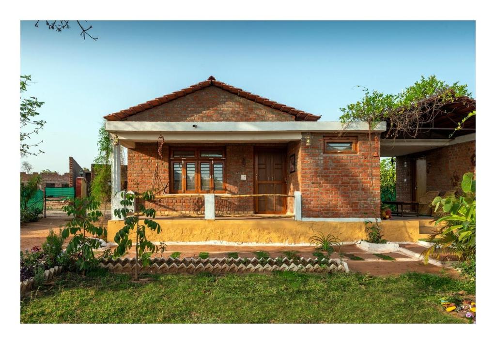 a brick house with a front door and a yard at Mahua hill view Homestay in Orchha