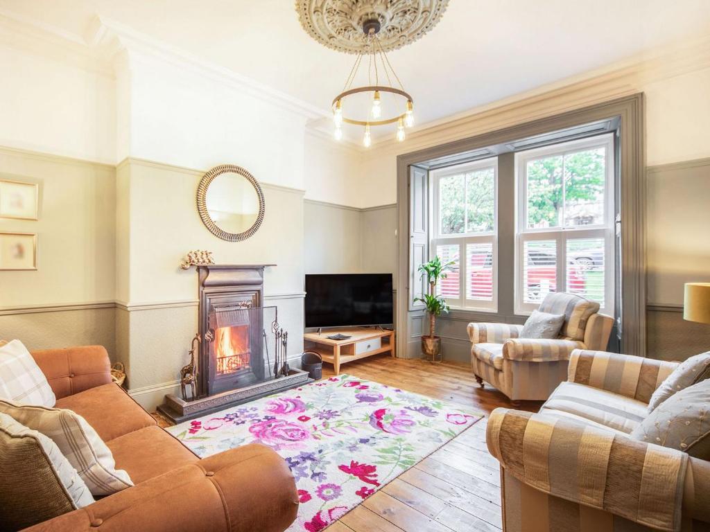 a living room with a couch and a fireplace at Carven House in Rothbury