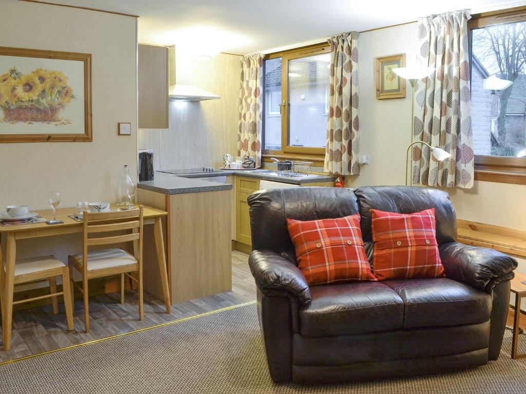 a living room with a leather couch and a kitchen at Toab - Uk5662 in Aberdeen