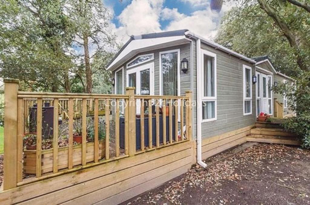 une maison avec une clôture en bois et une maison dans l'établissement Pet Friendly, Luxury Caravan For Hire In Suffolk By The Beach Ref 32203og, à Lowestoft