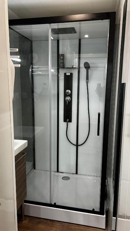 a shower in a bathroom with a phone in it at Embrun - Appartement 4&#47;6 personnes avec extérieurs in Embrun