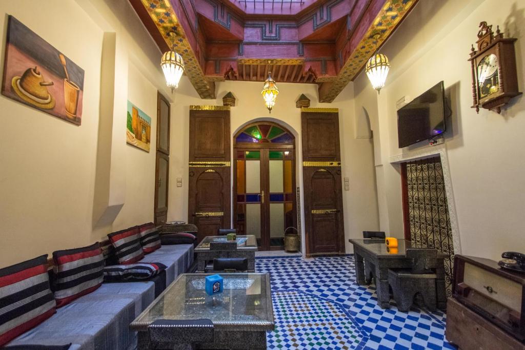 a living room with a couch and tables and a tv at Dar Chrif Idrissi in Fez