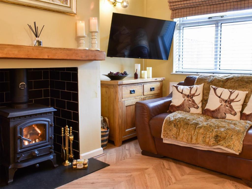 a living room with a couch and a fireplace at Gavels Gap in Nantwich