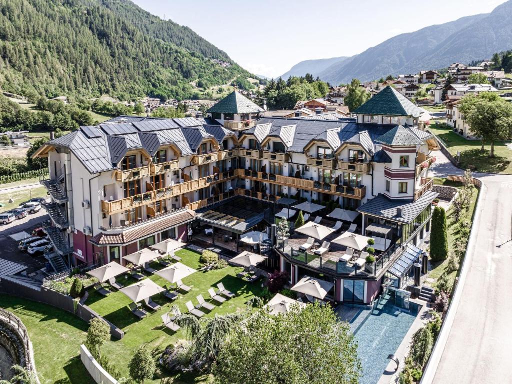 eine Luftansicht eines Hotels mit Bergen im Hintergrund in der Unterkunft Tevini Dolomites Charming Hotel in Commezzadura